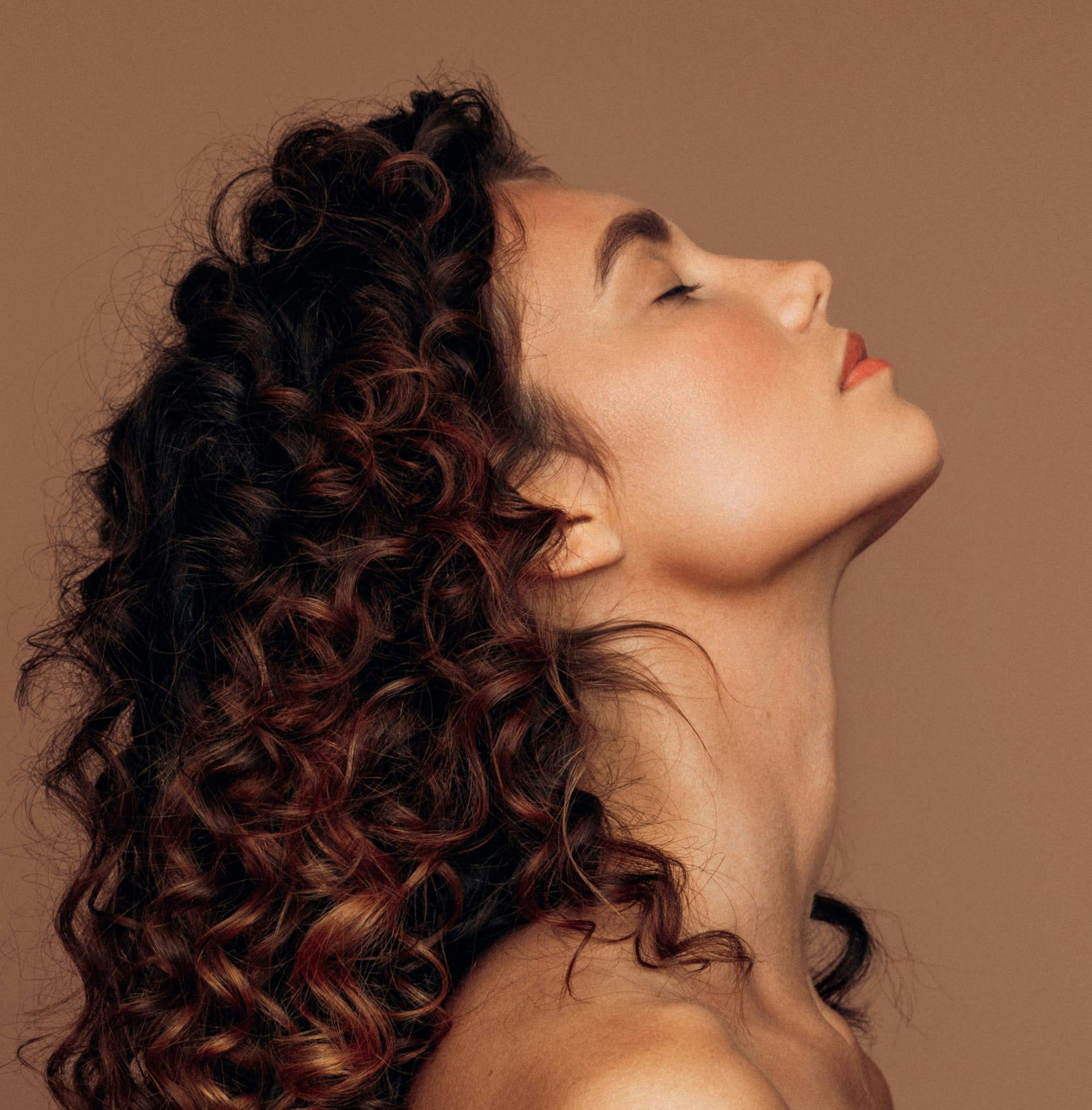 woman with fully curly hair side angle of her looking up
