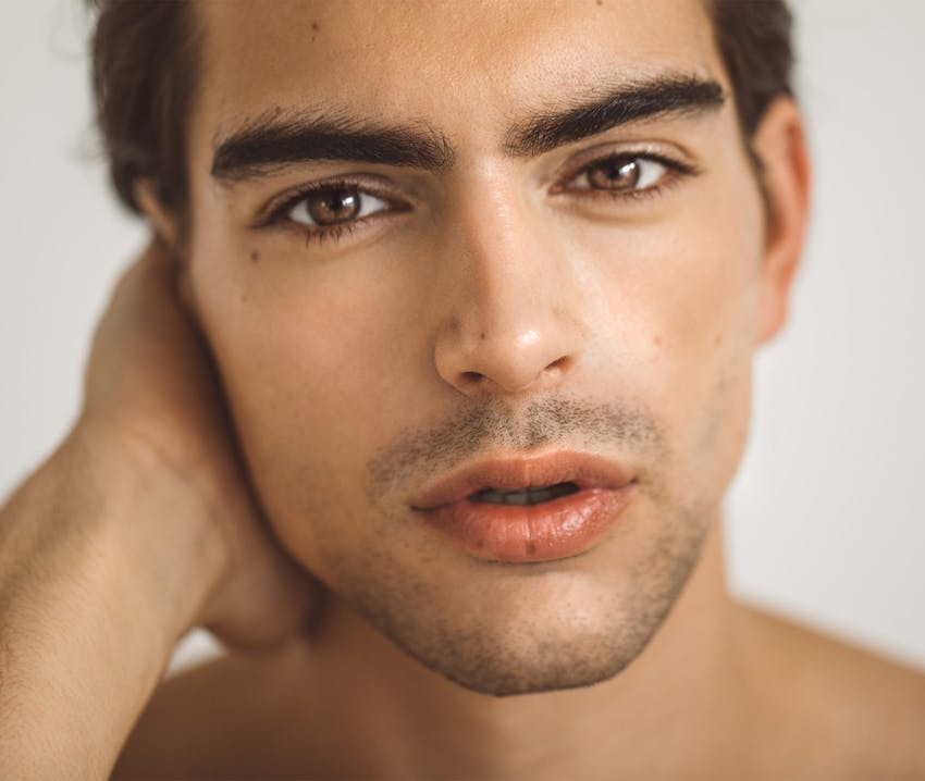 man close up with hand under his ear