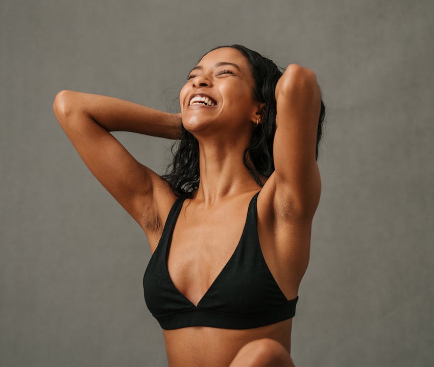 woman sitting on bed with arm next to her head