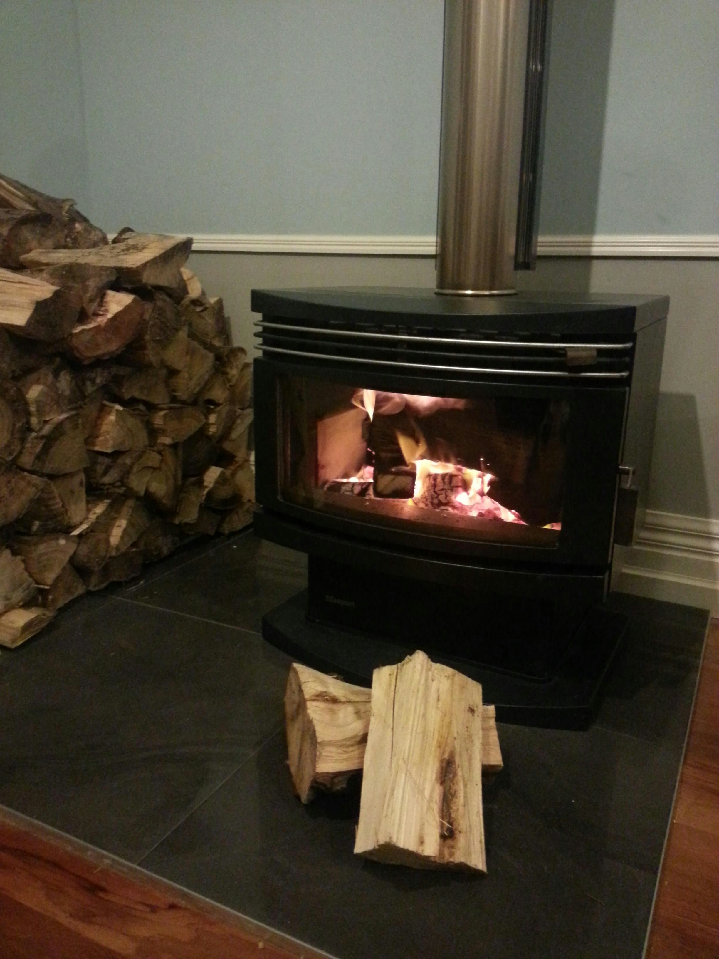 Fireplace in home with wood stacked to left