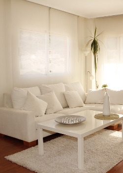 un salon avec canapé et table blanche
