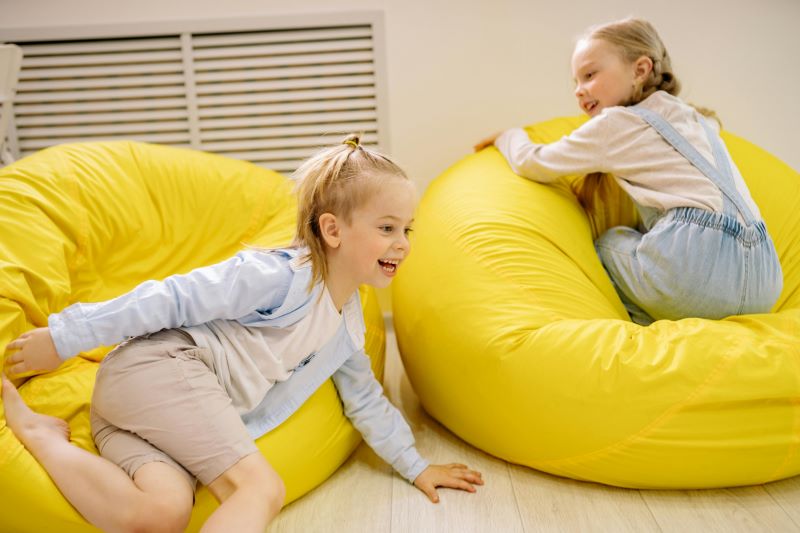 Enfants en crèche sur des poufs jaunes