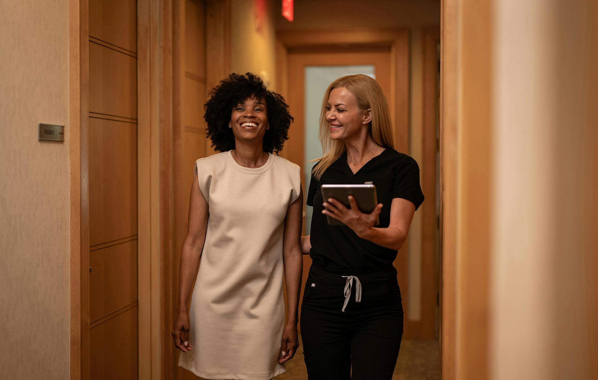 medical assistant walking patient down the hallway