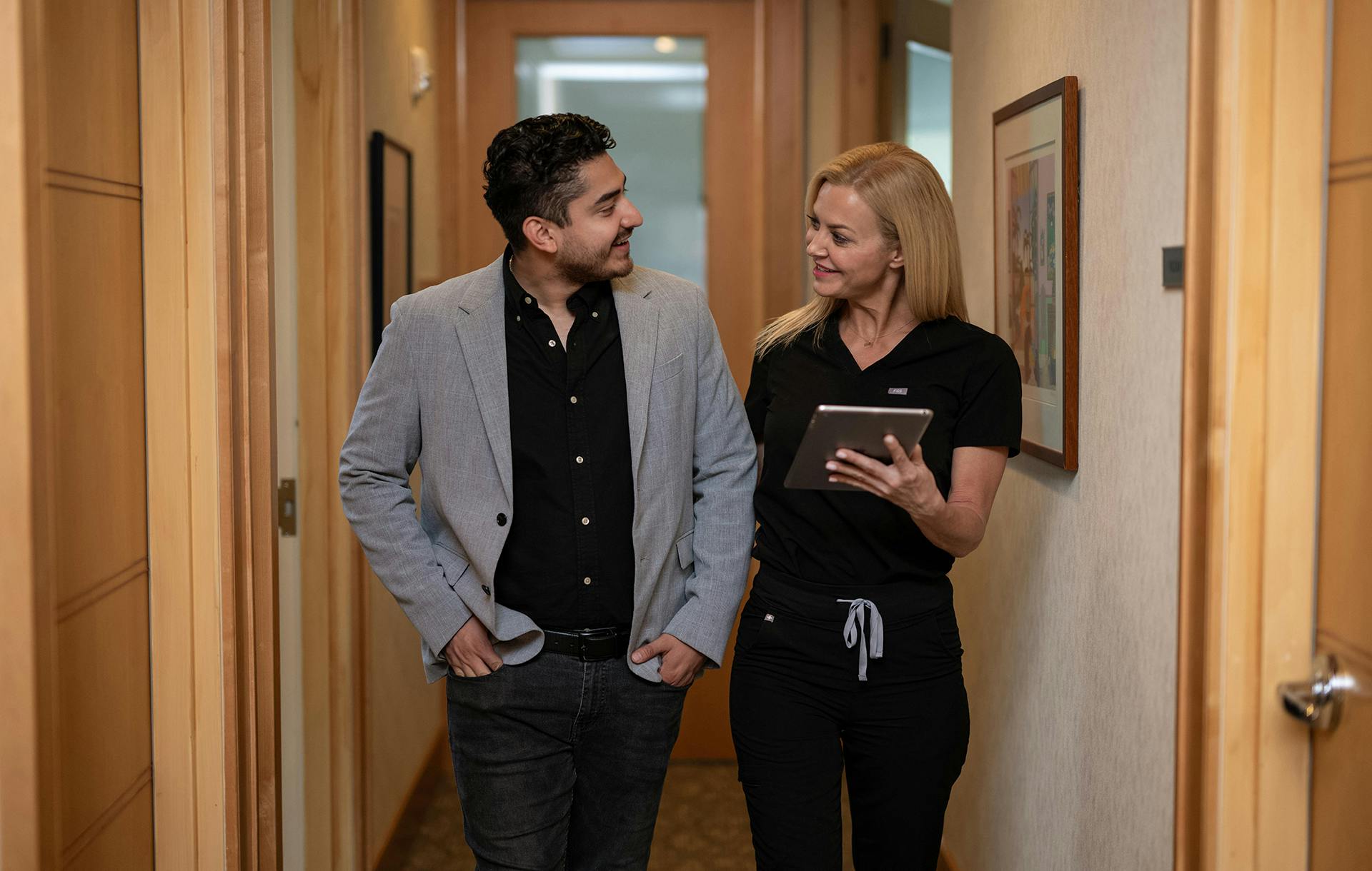 medical assistant walking patient down hallway