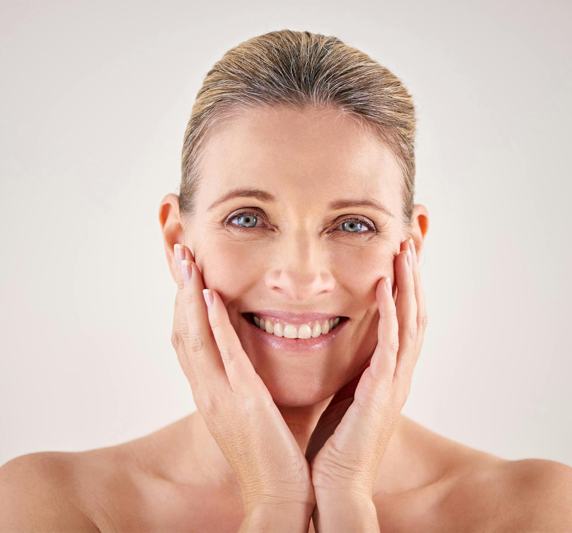 smiling woman with hands on face