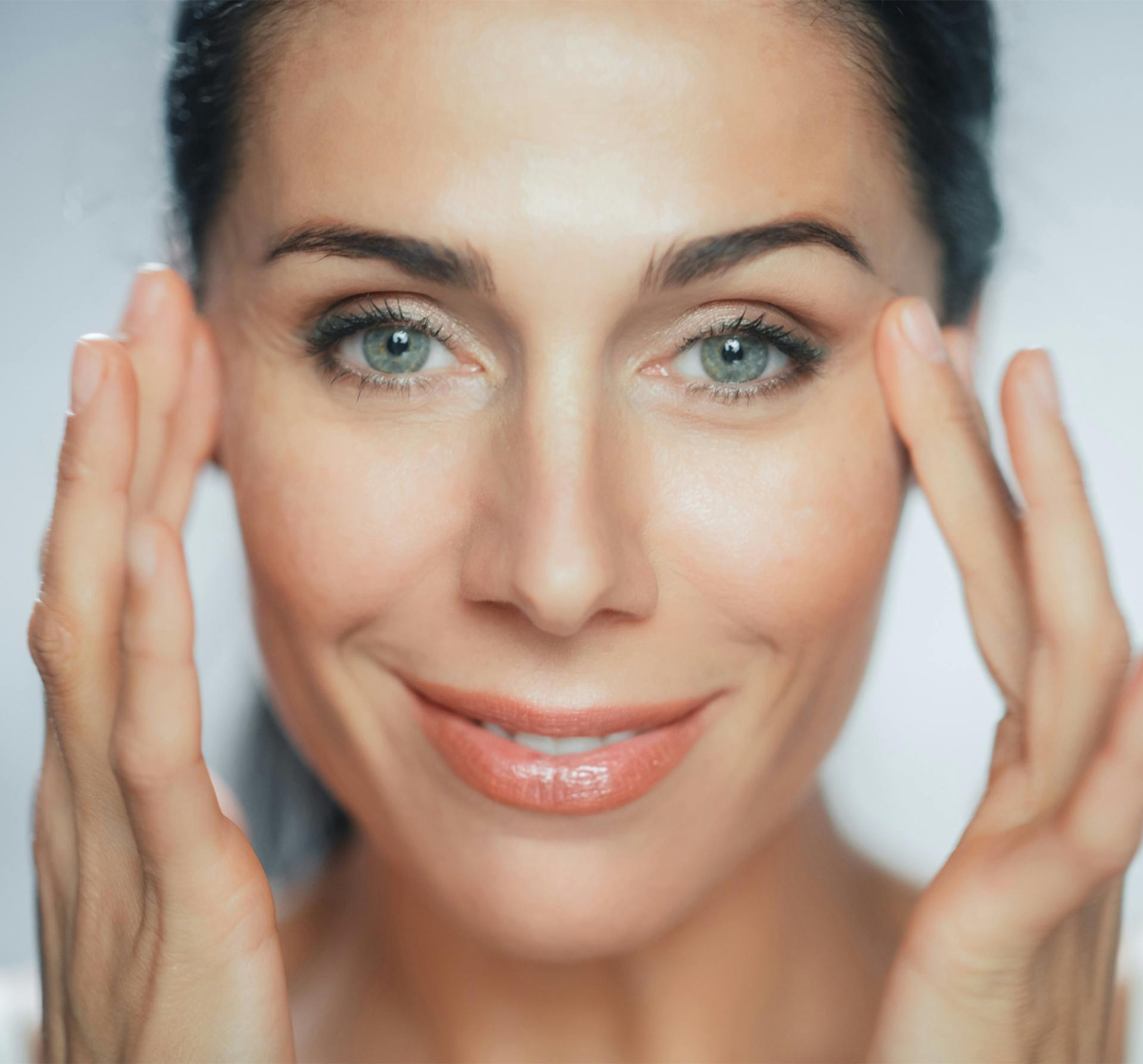 smiling woman rubbing sides of face