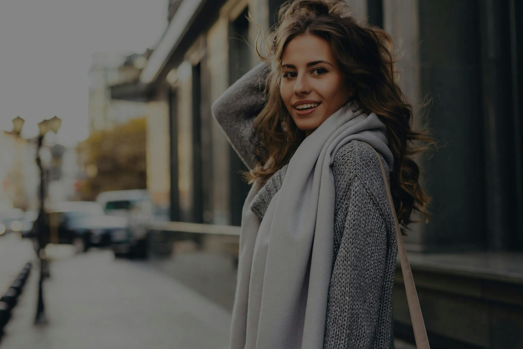 Woman in a coat standing on the sidewalk