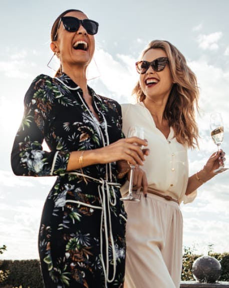 Two woman holding champagne and smiling