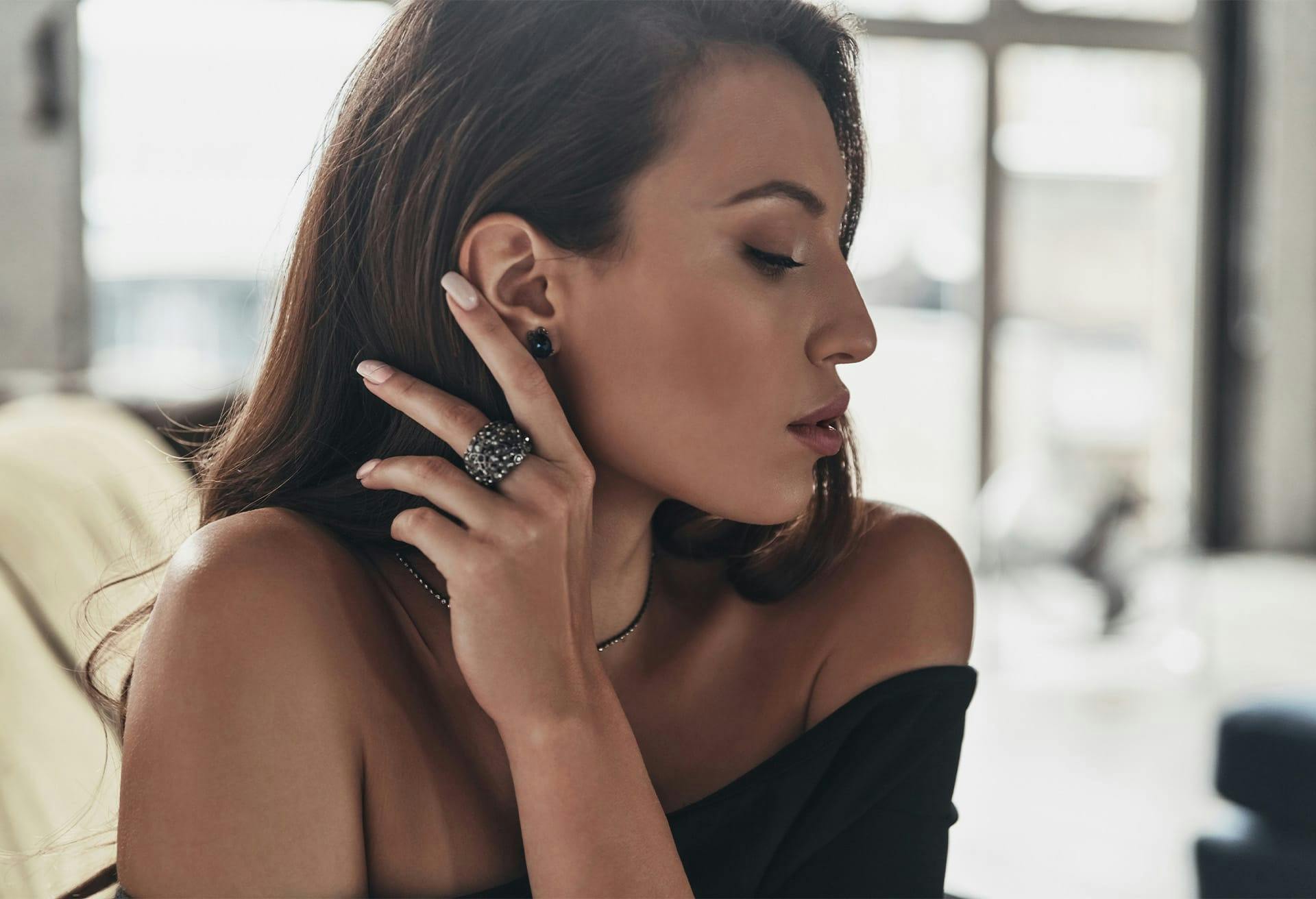 Brunette woman pushing hair behind ear