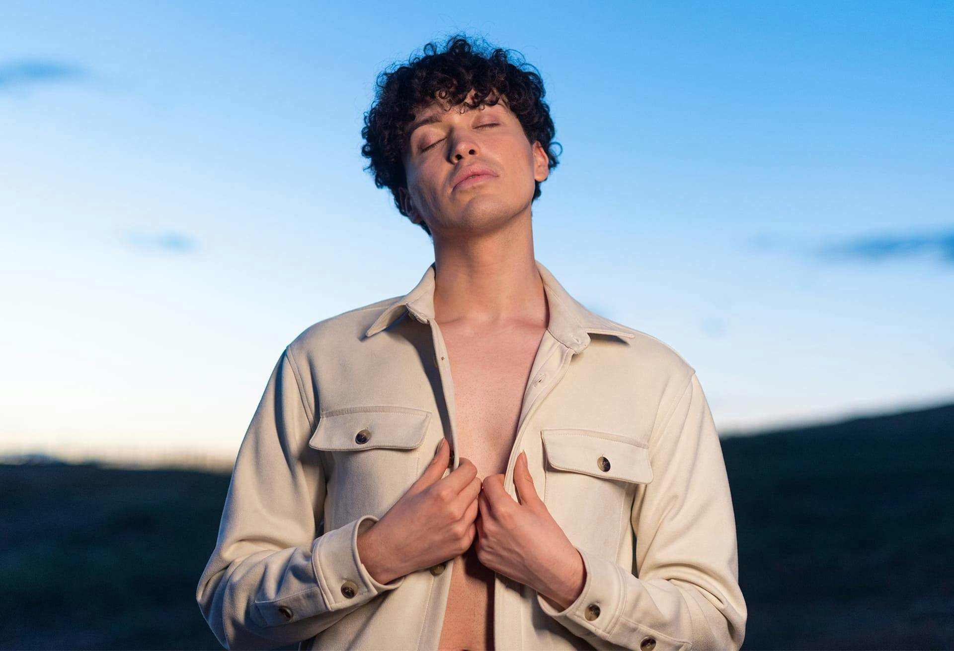 Man with open shirt at sunset