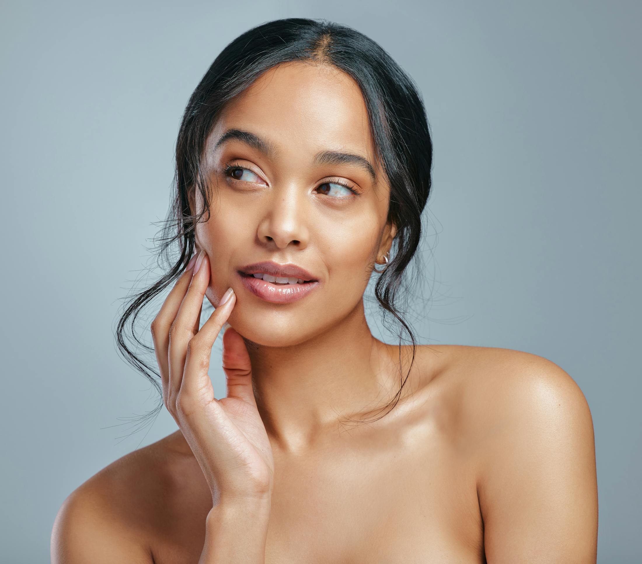 Woman touching her face and looking to the side