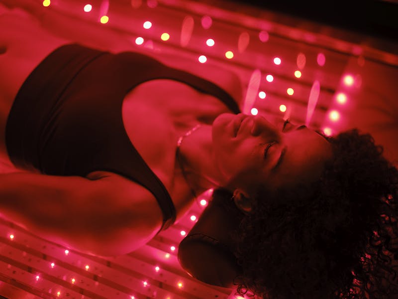 woman laying in a red light bed