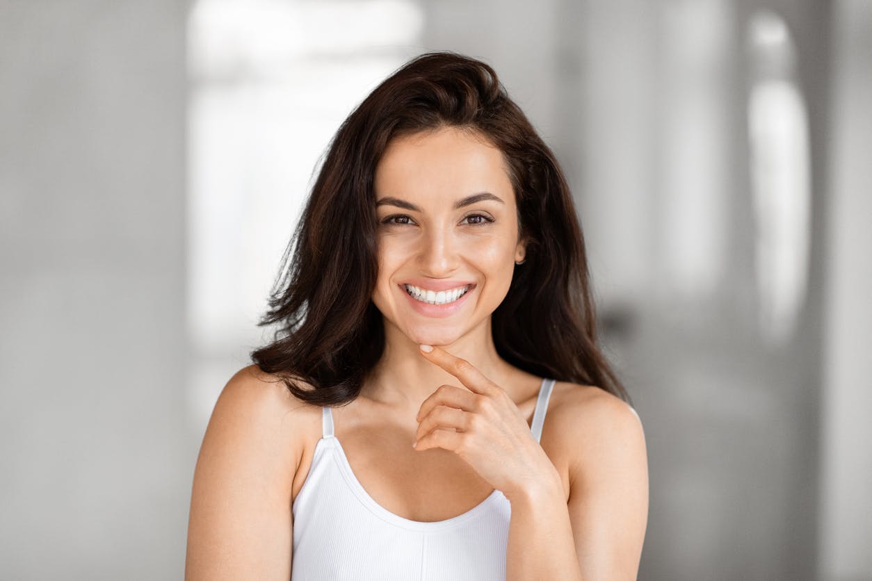 woman with short brown hair in a white tank top