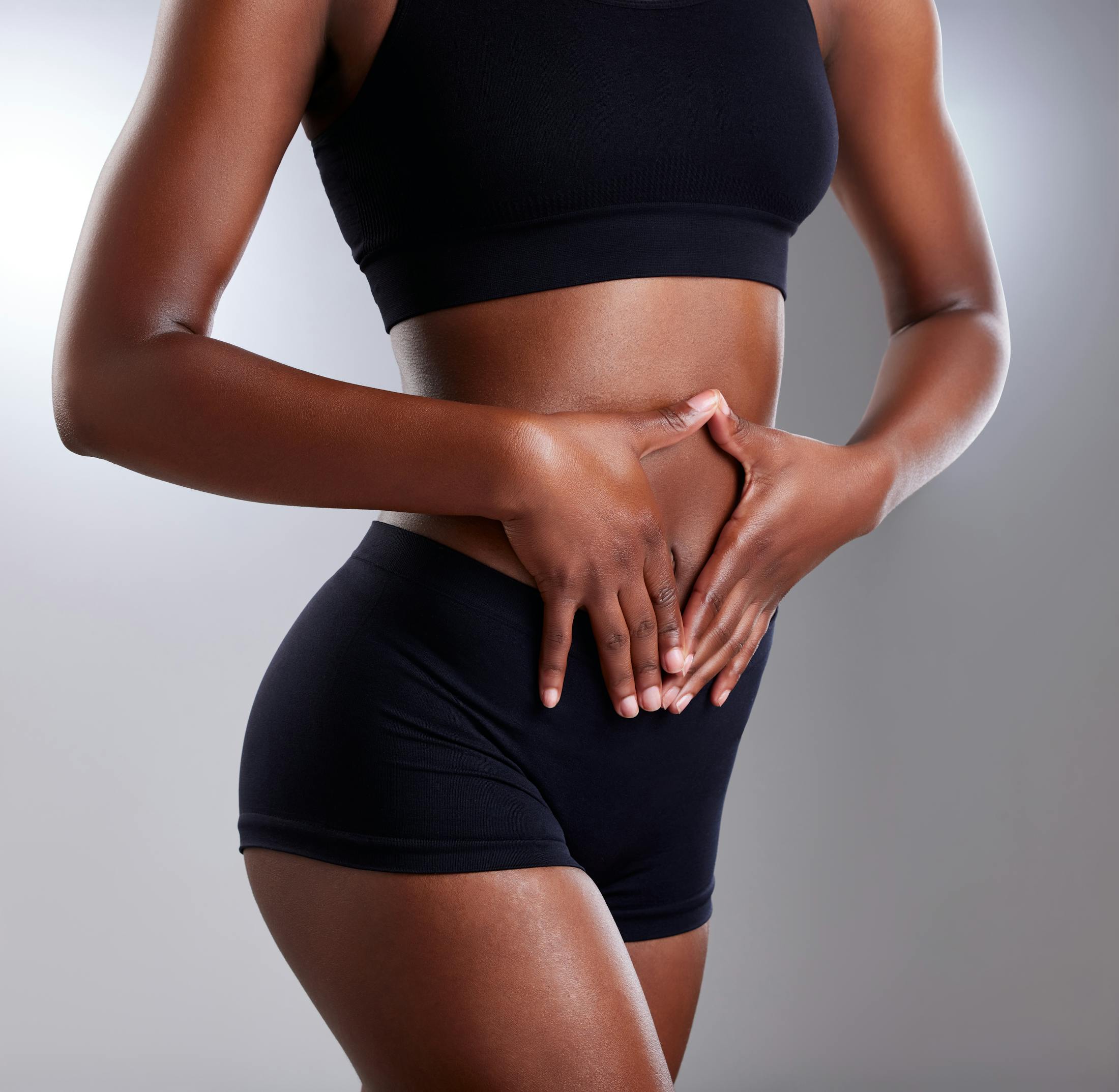 woman holding her hands over her midsection