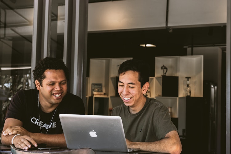 Two men working on a laptop