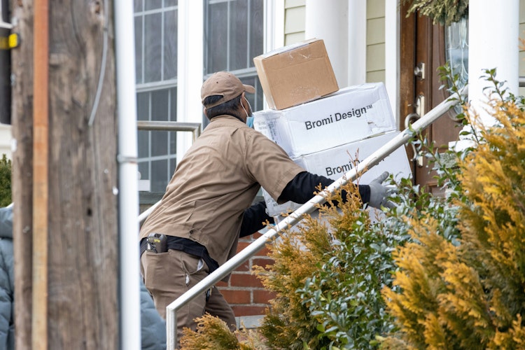A delivery person carrying package A delivery person carrying package