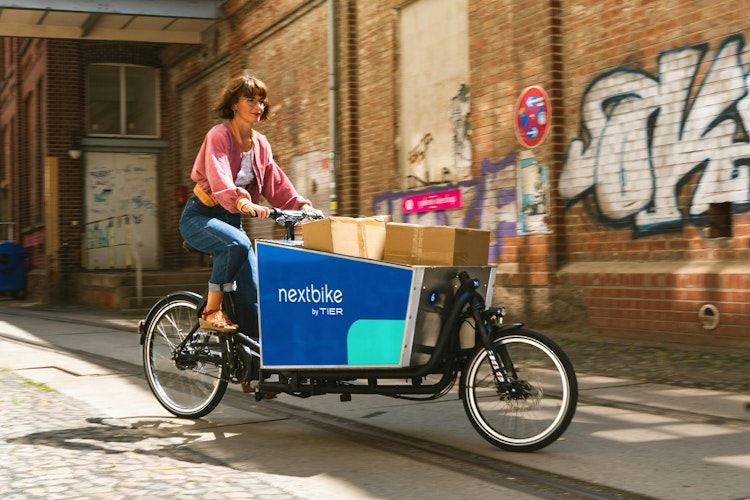 A women delivering parcels in the last mile with a cargobike
