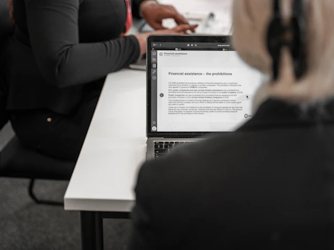 Student reading financial documents on a laptop