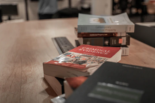 A series of stacked law textbooks on a wooden desk
