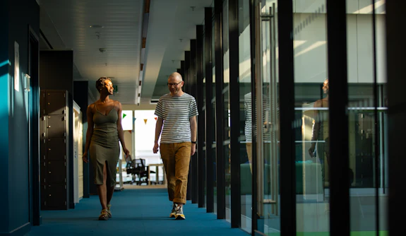 A man and a woman walking down a hallway