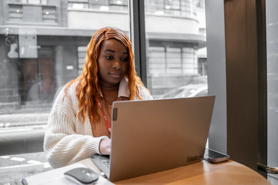 A woman sits in a cafe on a laptop computer