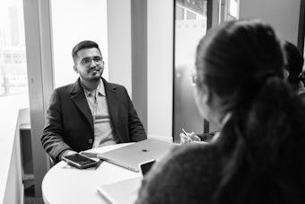 A male learner sits across from a female lecturer