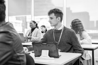 A male student listens attentively in a classroom