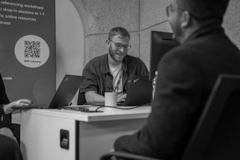 A male member of staff speaks to a student