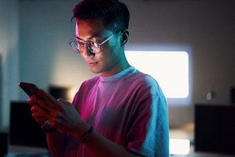 A young male looks at a mobile phone