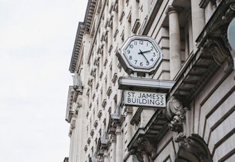An exterior shot of a clock on a building with the words St James's Building underneath it