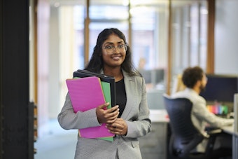 Woman walking holding files
