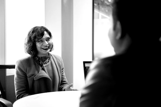 A female lecturer speaks to a male student across a desk