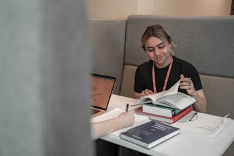 A male student reads a book in a study booth