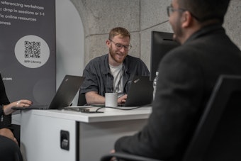 A male member of staff speaks to a student