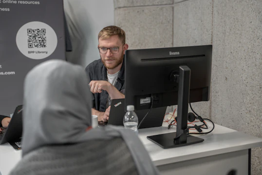 A male member of staff speaks to a student