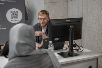 A male member of staff speaks to a student