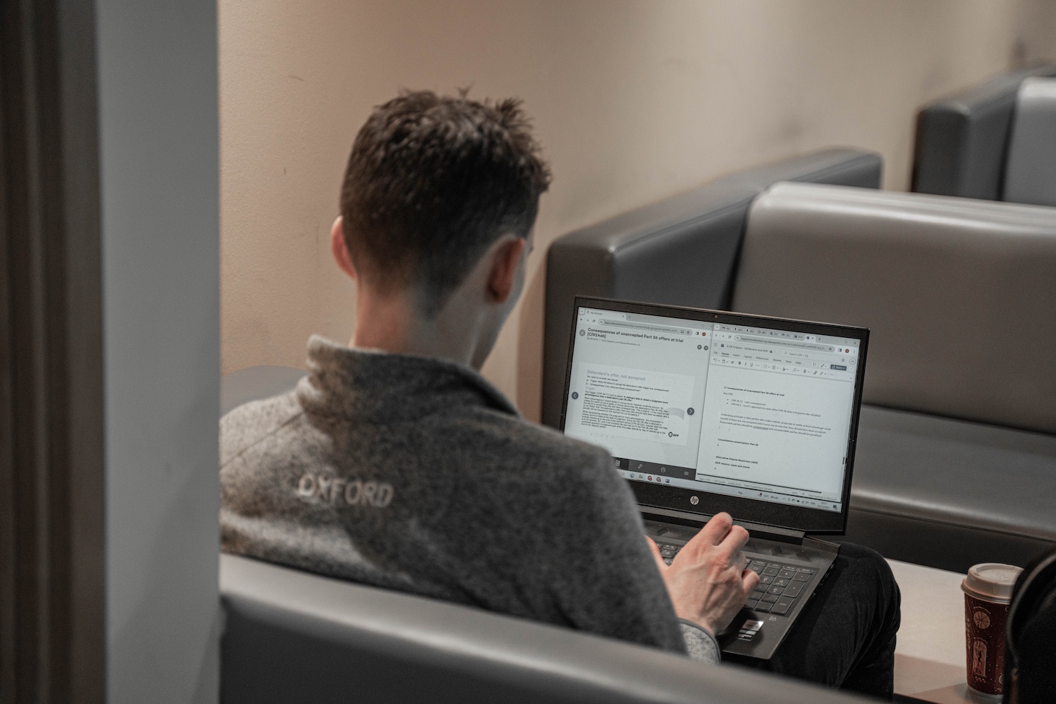 A student sits on a sofa with a laptop computer