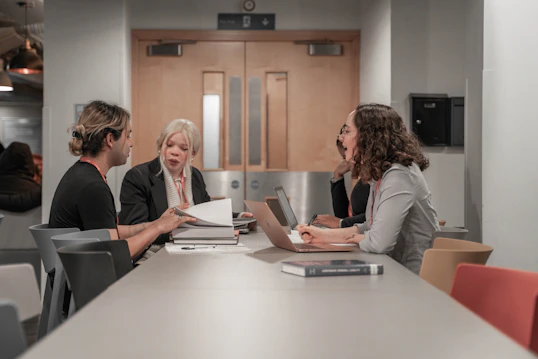 A group meeting between staff and students across a large table