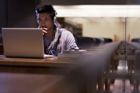 Student looking at a laptop with headphones on