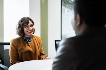 A female member of staff speaks to a student