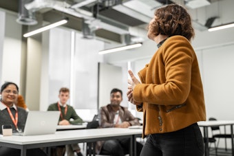 A woman speaks to a class of students