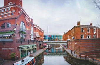 Shops, brick buildings and boats line the canal at Brindleyplace in Birmingham