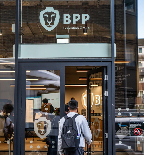 A student with a backpack walks into a BPP centre