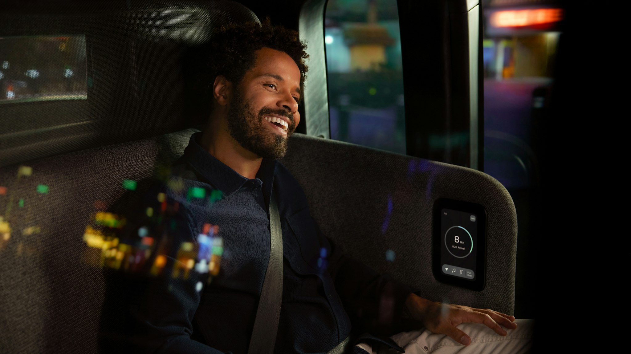 Man happily looks out the window of a Zoox robotaxi