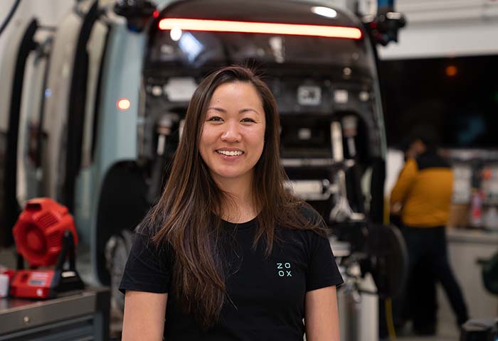 Zoox employee Justine in front of a Zoox vehicle