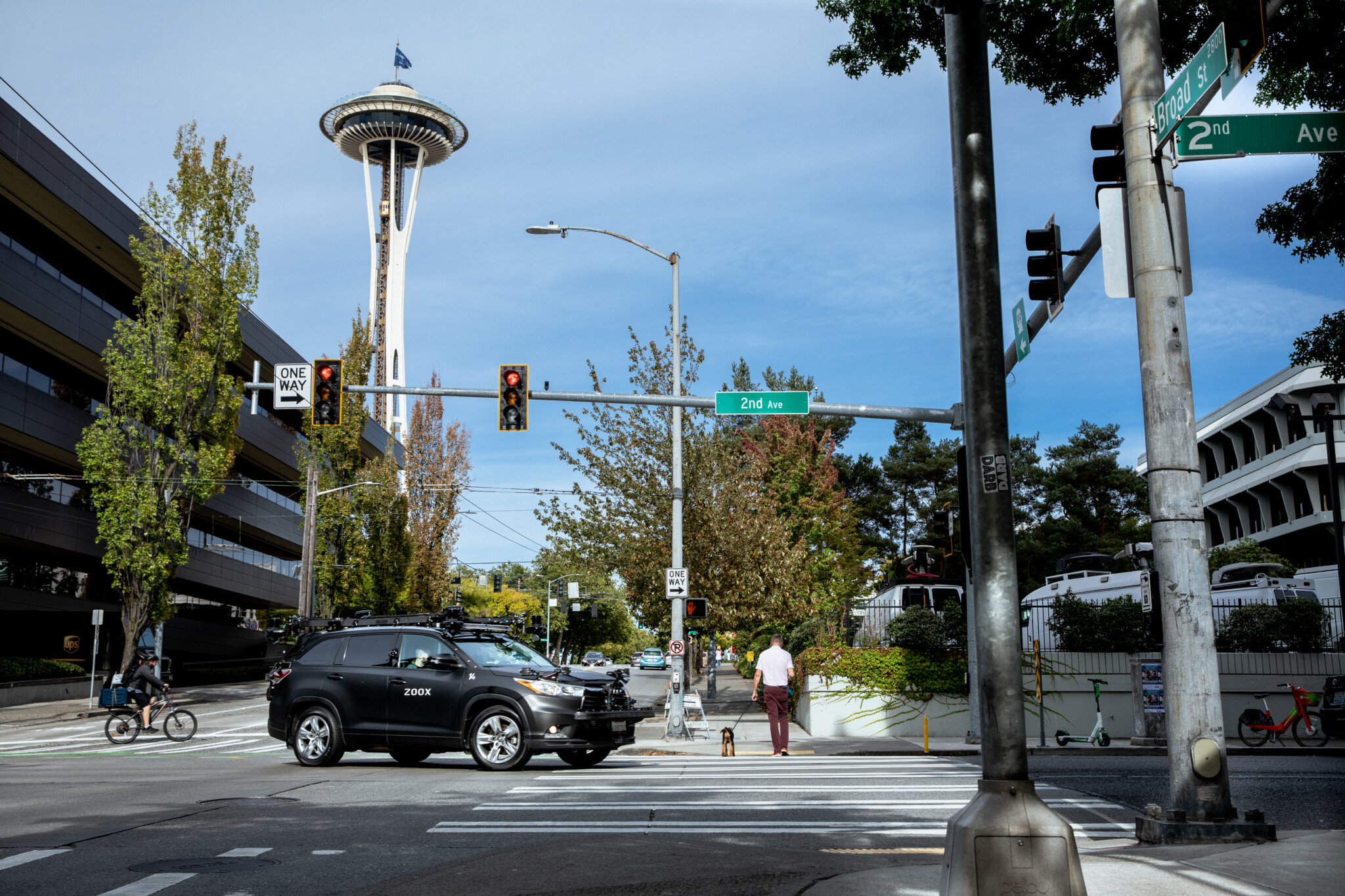A Zoox test vehicle drives in front of the Seattle Space Needle