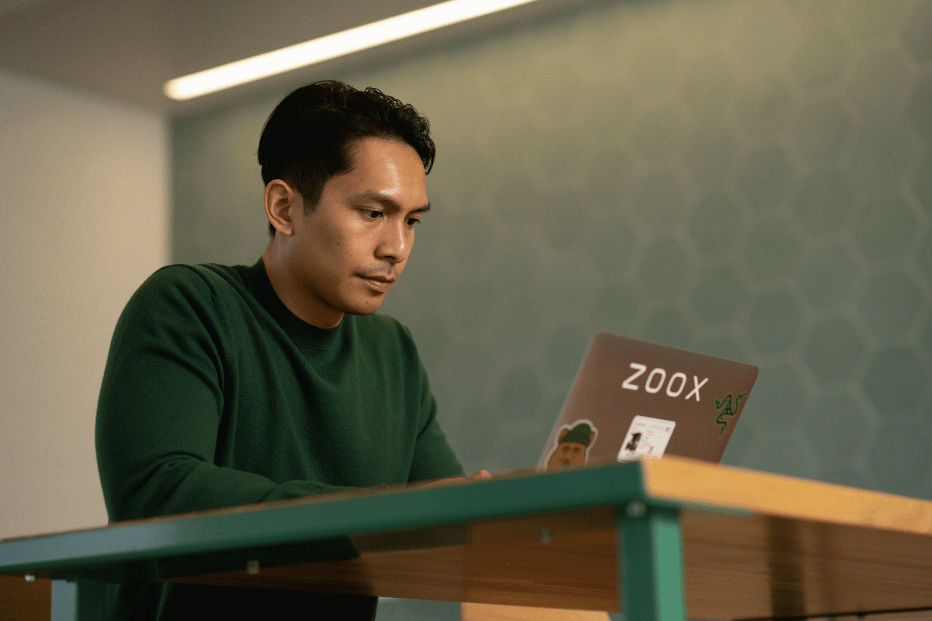 Zoox employee Reymark working on his laptop in Zoox office