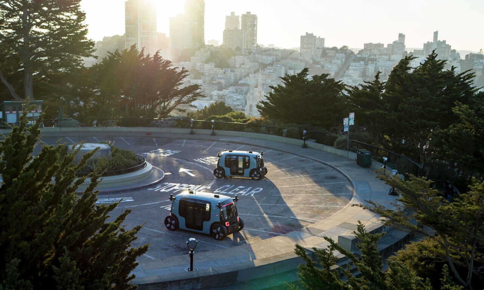 two zoox robotaxis parked in a lot in san francisco