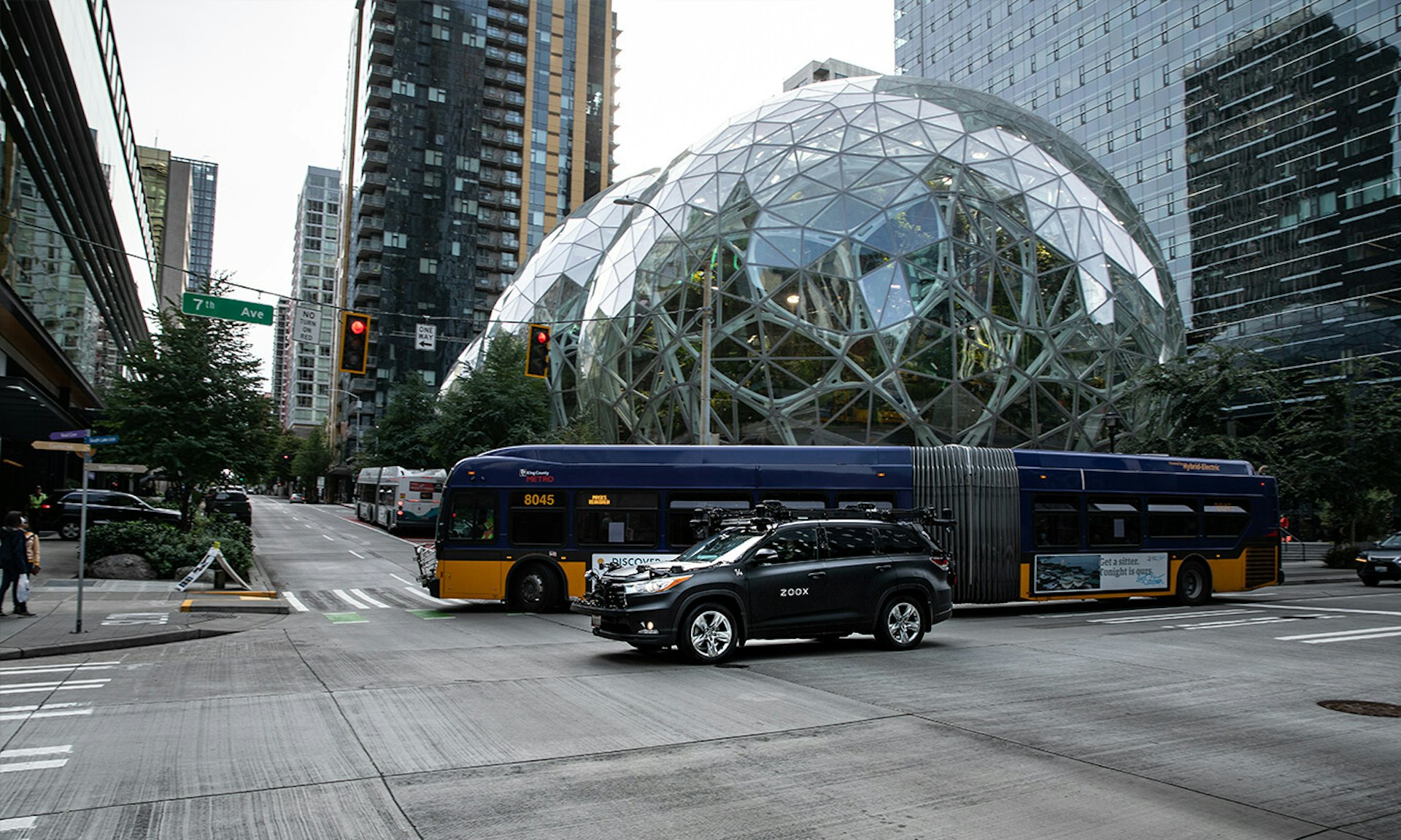 zoox test vehicle driving on the street in seattle near amazon building