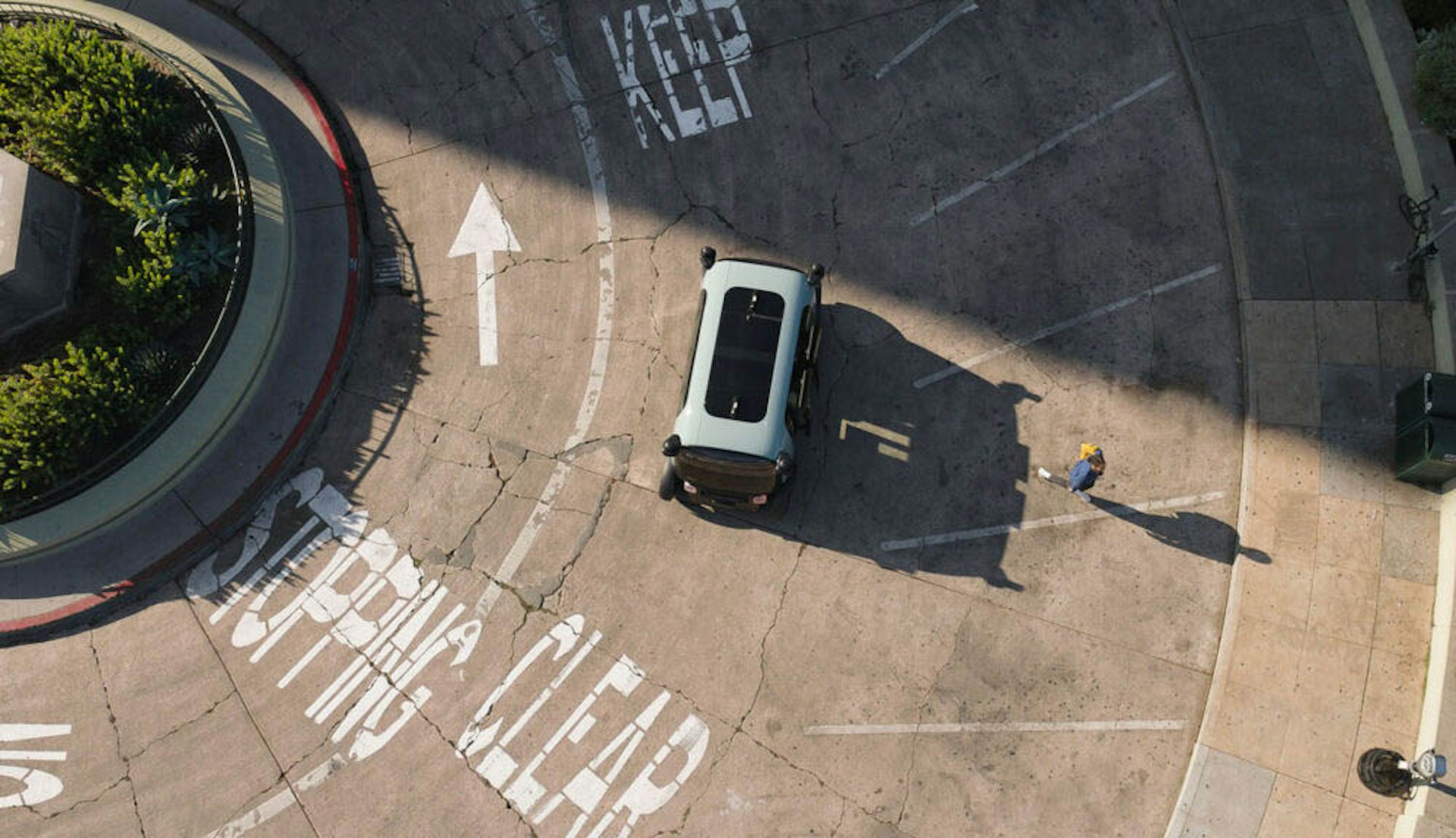 aerial view of zoox robotaxi in a parking lot with a person walking away